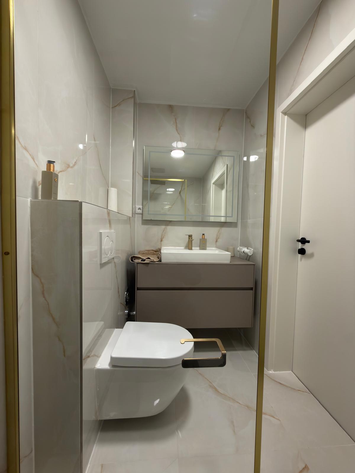 Badezimmer mit hellen Fliesen und hochwertiger Ausstattung